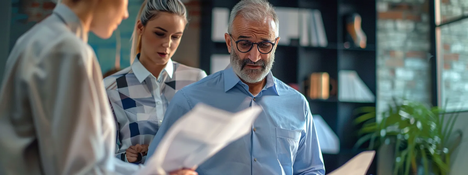 business professionals examining different types of fabric on men's short-sleeve shirts in a conference room setting.
